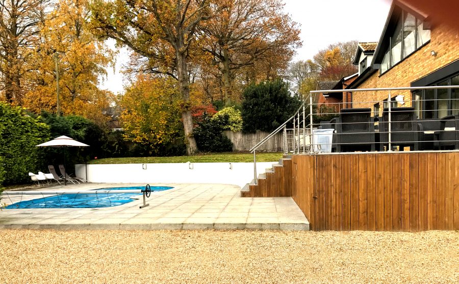 Bespoke swimming pool with raised decking and seating area designed and built by Nationserv
