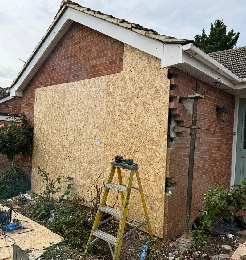 Temporary plywood and insulation covering the impact area at the Oxford property after Nationserv made the home weathertight